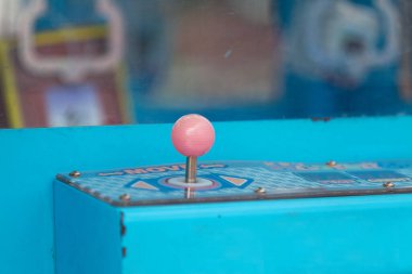 Close-up on the joystick of a claw machine.