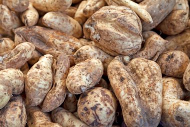 Close-up on a stack of Sweet Potatoes for sale on a market stall.