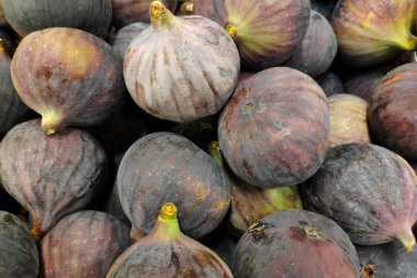 Close-up on a stack of figs for sale on a market stall.