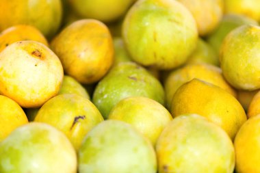 Close-up on a stack of mangoes for sale on a market stall.