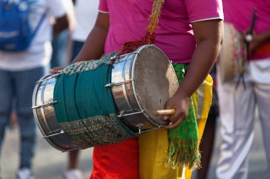 Percussionist playing with a dholak during the carnival of the Grand Boucan.