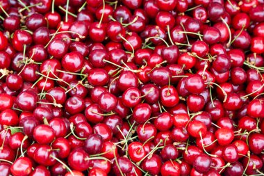Close-up on a stack of cherries for sale on a market stall.