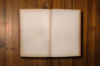 Close-up on a red book opened with copy space on a brown woodboard.