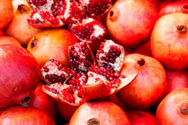Close-up on a stack of pomegranates for sale a market stall.
