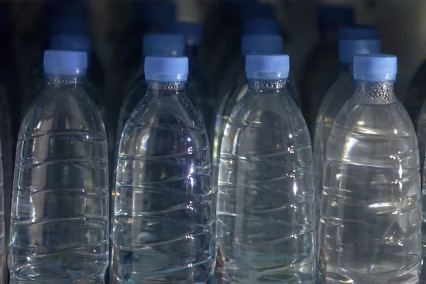 Close up on water bottles in a vending machine.