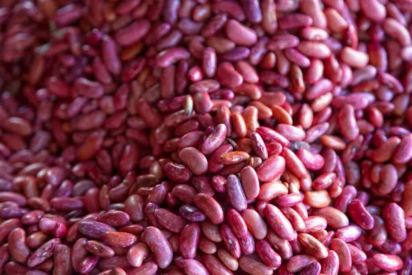 Full frame close-up on a stack of red beans on a market stall.