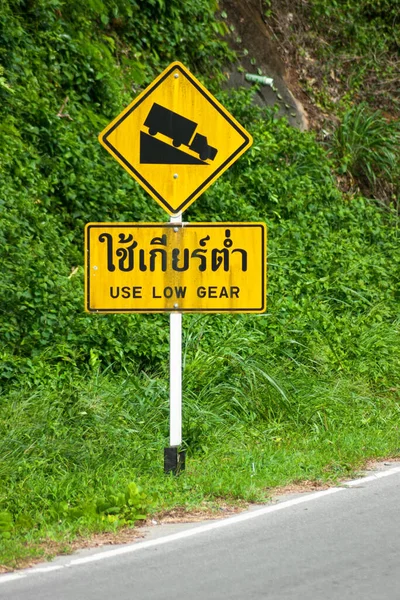 Thai yellow warning sign stating both in english and thai : Use low gear.