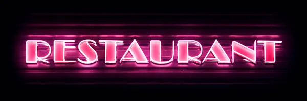 Close-up on a pink neon light shaped into the word 
