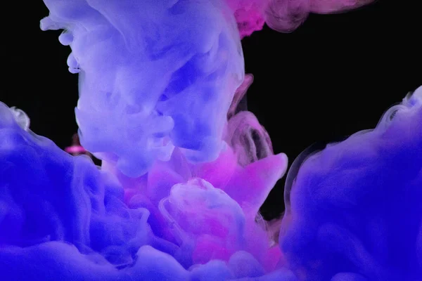 Blue and magenta paint swirling underwater on black background.