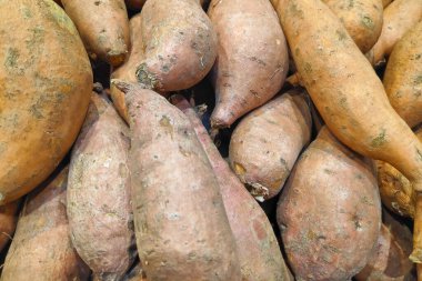 Close-up on a stack of Sweet Potatoes for sale on a market stall.