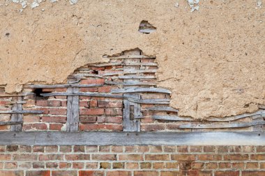 Full frame close-up on a half-timbered brick wall covered with daub.
