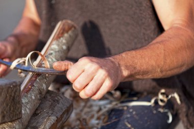 Medieval carpenter rabotting a branch of wood during the annual 
