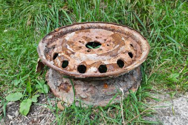 Close-up of a rusted car rim abandoned in nature.