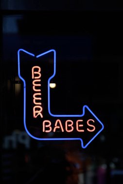 Close-up on a blue neon light shaped into an arrow pointing right with a reon 