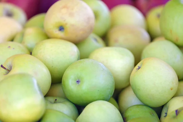 Close up on a stack of Granny Smith apples on a market stall.