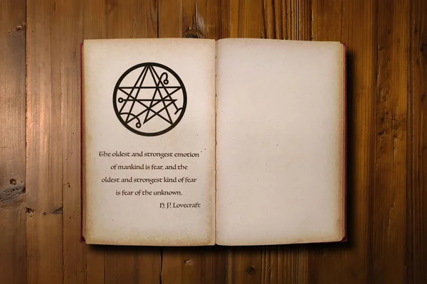 Close-up on an opened dark fantasy book with a the sigil of the Gateway with beneath, a quote from H. P. Lovecraft saying \