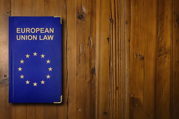 Close-up on an European Union law book with a gilded EU flag symbol in its middle.