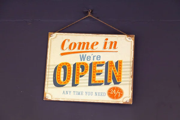 Sign hanging at the door of a shop saying: 