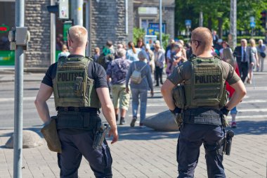 Tallinn, Estonya - 15 Haziran 2019: Kurşungeçirmez yelek giyen iki polis Estonya Ulusal Operasının girişindeki kalabalığı kontrol ediyor.