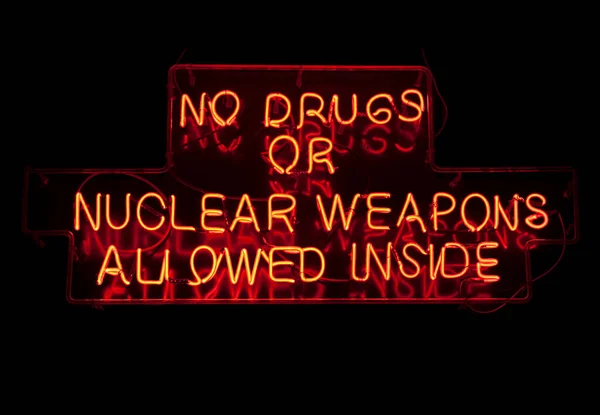 次の警告に形をした面白いネオンライト 内側に許可されている薬や核兵器はありません — ストック写真