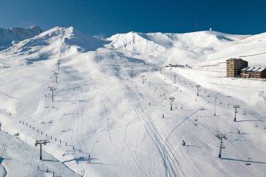 Kayak asansörleri, Pas de la Casa 'dan Grandvalira' nın karlı dağlarının tepesine doğru gidiyor..