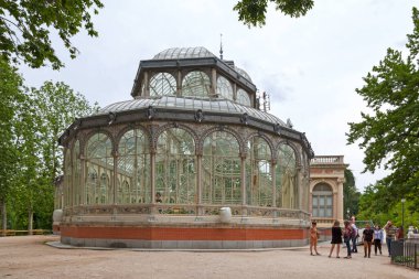 Madrid, İspanya - Haziran 07 2018: Turistler ve yerliler Kristal Saray 'ın (Palacio de Cristal) önünde toplandılar. 1887 'de Filipinler' deki bitki ve hayvanları sergilemek için inşa edildi..