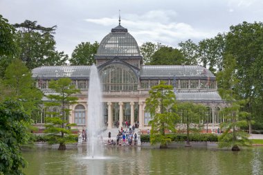 Madrid, İspanya - Haziran 07 2018: Turistler ve yerliler Kristal Saray 'ın (Palacio de Cristal) önünde toplandılar. 1887 'de Filipinler' deki bitki ve hayvanları sergilemek için inşa edildi..