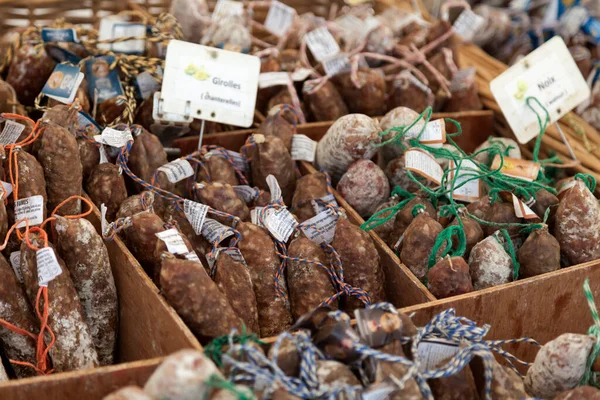 stock image Wide range of dry-cured sausages (saucisson sec) for sale on a market stall.