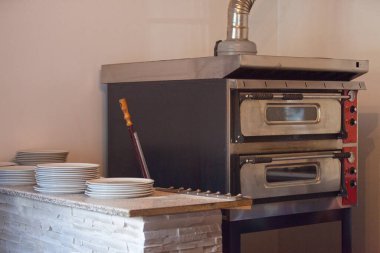 Yanları pizza fırını, pizza kabuğu ve pizza tabakları..