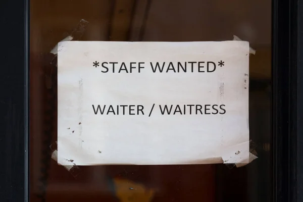 スタッフ募集 ウェイター ウエートレス と書かれたレストランの窓の内側に紙が貼られています — ストック写真
