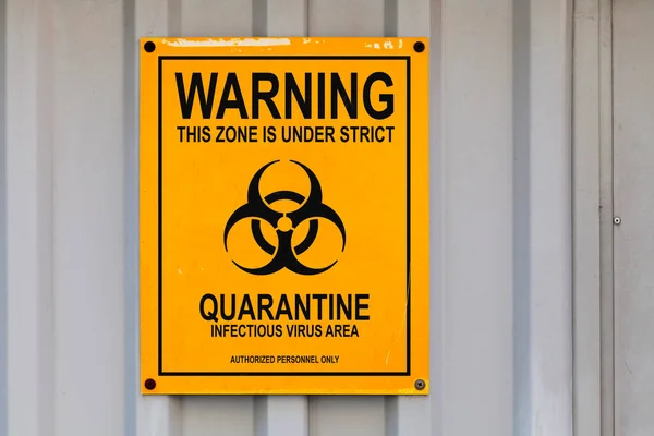 警告标志画在黑色和黄色的标牌上 上面写着 这个区域被严格隔离 传染性病毒的区域 只有受权人员 中间有一个生物危害符号 — 图库照片