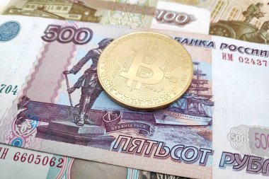 Rus Rublesi banknotlarının üstünde altın bir Bitcoin 'e yakın plan..