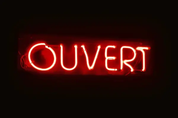 Close-up on a red neon light shaped into the  French word \