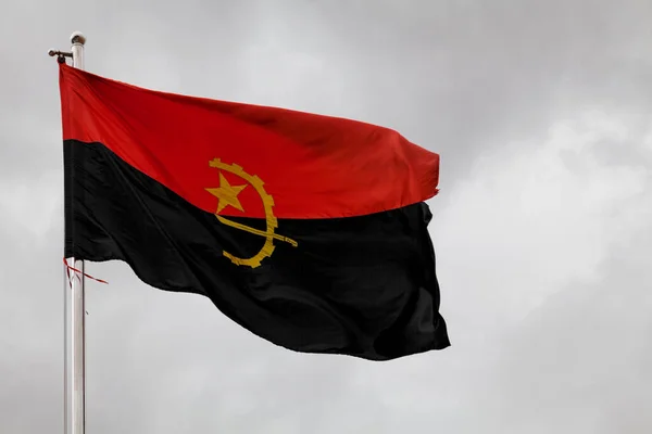 安哥拉国旗在杆子顶上飘扬 — 图库照片