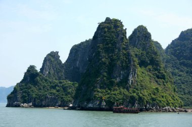 Gemi Ha Long Bay, Vietnam 'da bir adanın yanında demirlemiş..