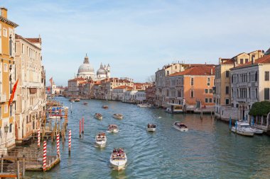 Venedik, İtalya - 07 Mart 2019: Santa Maria della Salute Bazilikası, Sina Centurion Sarayı, Palazzo Da Mula Morosini, Palazzo Barbarigo ve Palazzo Loredan Cini gibi ünlü şehir simgelerinden geçen taksi botları.