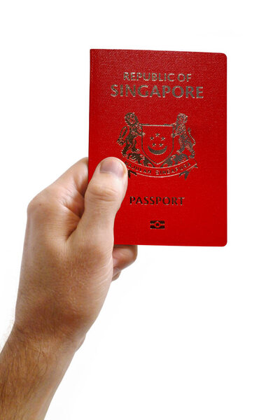 Close-up on a man's hand holding an Singaporean passport against a white background.