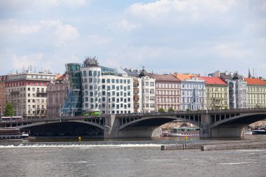 Prag, Çek Cumhuriyeti - 16 Haziran 2018: Jirsek Köprüsü Vltava Nehri 'ni arkası ile geçiyor, mimarı Frank Gehry' nin eğri büğrü modern ofis bloğu, şehir manzarası sunan şehir manzaralı Jirsek Köprüsü.