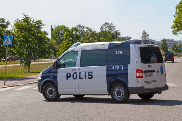 Helsinki, Finland - June 19 2019: Police van patrolling the streets near a public park.