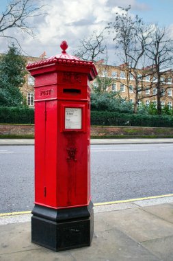 1866 'da üretilen altı köşeli kırmızı bir Penfold posta kutusu. Posta kutusunda Kraliçe Victoria 'nın VR harfleri var..