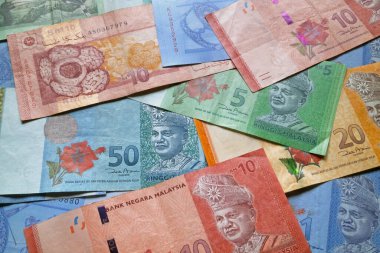 Arka plan olarak Malezya ringgit banknotları yığını.