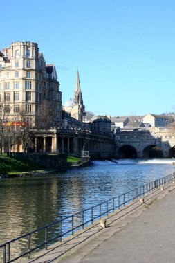 Pulteney Weir, Bath Market 'in karşısında ve arkasında Pulteney Köprüsü ile Avon Nehri ve St Michaels & St Pauls Kilisesi' ni geçmektedir..