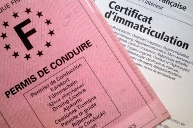 Bir permis de conduire (sürücü belgesi) ve bir karta (araç ruhsat belgesi) yakın çekim. Fransa 'da araba kullanabilmek için, bir sürücünün bu belgelerin yanı sıra geçerli bir sigortaya da sahip olması gerekir..