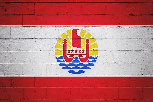 Flag of French Polynesia painted on a cinder block wall.