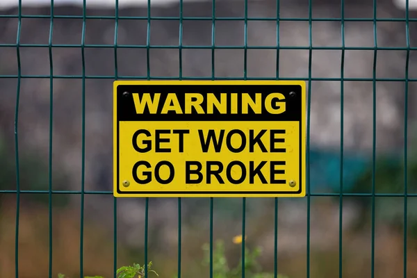 Warning sign on a fence stating in 
