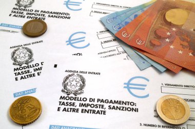 İtalyan vergi formunun üzerine biraz avro sikkeleri ve banknotlar (Mod. F23).