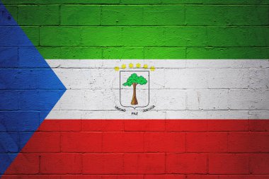 Bir tuğla duvara boyanmış Ekvator Ginesi bayrağı.