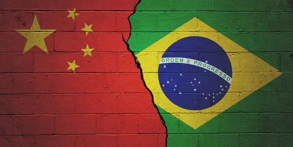 Cracked brick wall painted with an Chinese flag on the left and an Brazilian flag on the right.