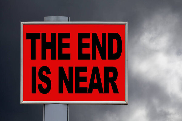 Close-up on a red billboard against a stormy sky with the message "The end is near" written in the middle.