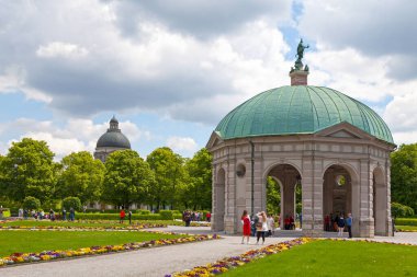 Münih, Almanya - 30 Mayıs 2019: Diana 'nın pavyonu (Dianatempel) ve ağaçların üzerindeki Bayerische Staatskanzlei Kubbesi ile Saray Bahçesi (Hofgarten).